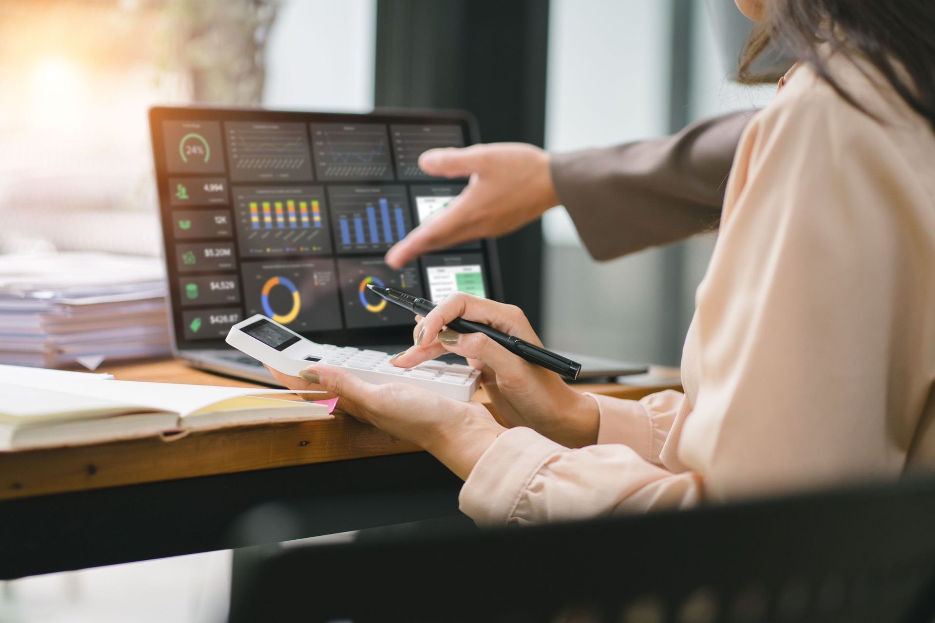 A businesswoman or accountant using laptop to analyze financial investments and business and marketing growth on a data graph. The concepts of accounting, economics, and commercial analysis.